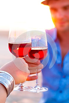 Close-up of two humanÃ¢â¬â¢s hand with wineglasses red wine during photo